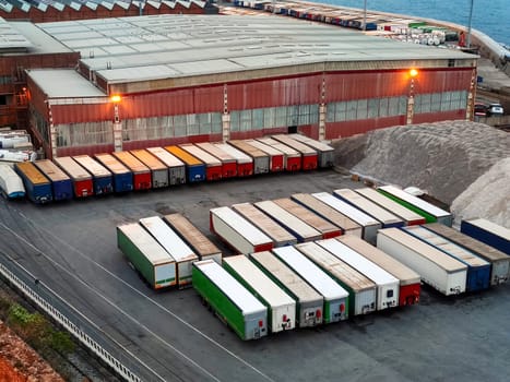 Commercial port with parked cargo prepared for the worldwide transportation of raw commodities, logistics, and global industry