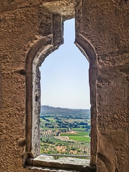 the interior of an old stone castle while looking out at the French hills in the background.