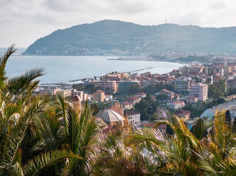 Ligurian coast of the town of Diano Marina with sea, mountains and palm trees on the first floor, travel reportage during the summer in Italy