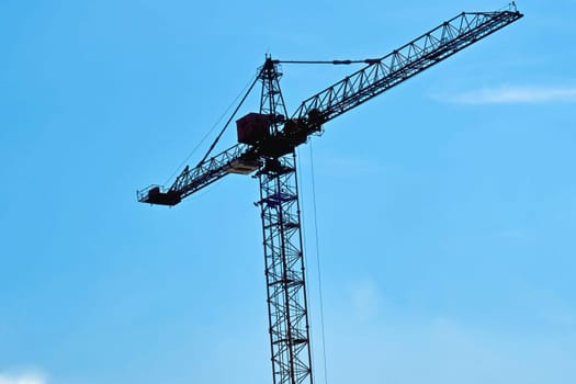 a large, tall machine used for moving heavy objects by suspending them from a projecting arm or beam.
