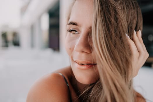 Happy woman portrait in cafe. Boho chic fashion style. Outdoor photo of young happy woman with long hair, sunny weather outdoors sitting in modern cafe