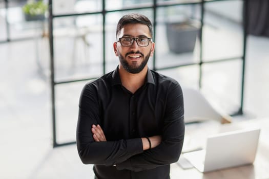 Businessman portrait. Happy confident young businessman standing , smiling, looking at camera.