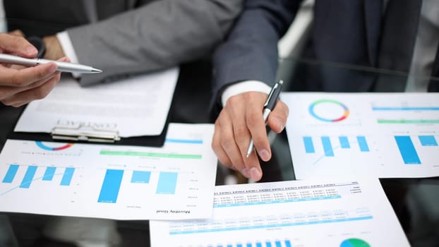 Businessman working at office desk, he is building a growing financial graph using wooden toy blocks. successful business concept