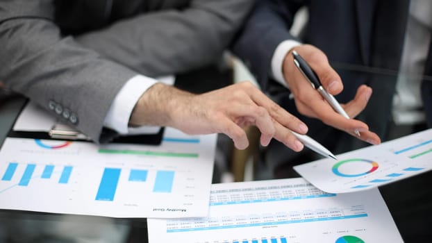 Businessman working at office desk, he is building a growing financial graph using wooden toy blocks. successful business concept