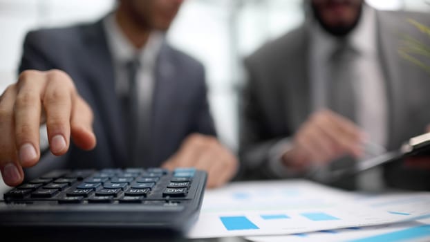Businessmen shaking hands at the board room table.