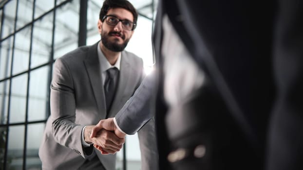 Two businessmen shaking hands at lunch meeting