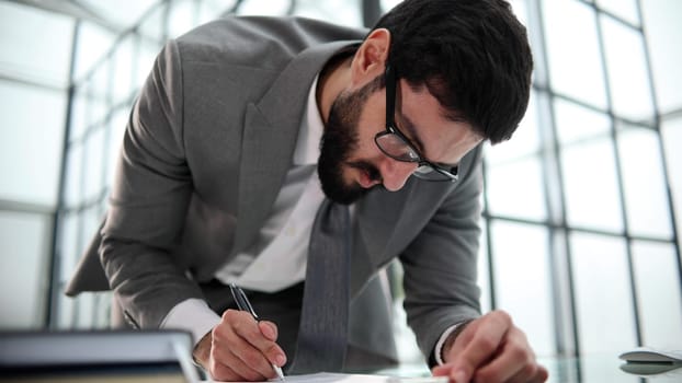 Young businessman signing a contract in the office