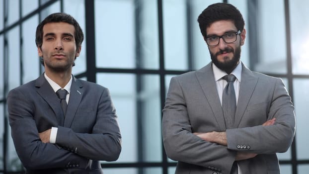 confident professional business men posing with arms crossed in office