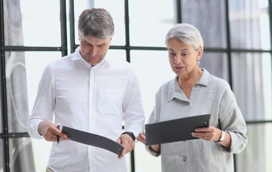 Businessman and businesswoman smiling looking at phone