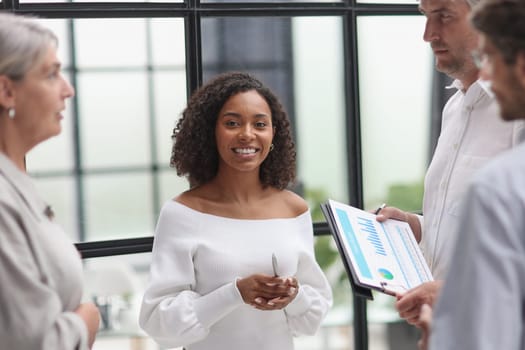 Negotiations in the office. Smiling businesswoman talks with colleagues