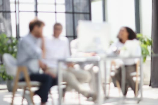 Conversation between managers and employees in the office. Blurred photo.