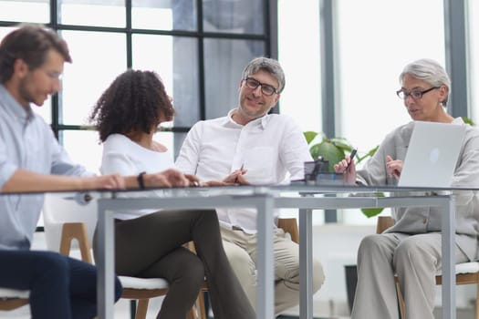 Serious team of professionals, business people negotiating in modern boardroom, discuss project