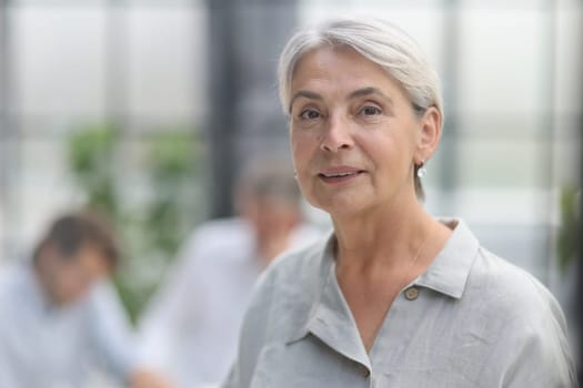 close-up mature woman holding a cup in the office.