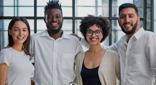 Portrait of successful creative business team looking at camera and smiling. Diverse business people standing together at startup.