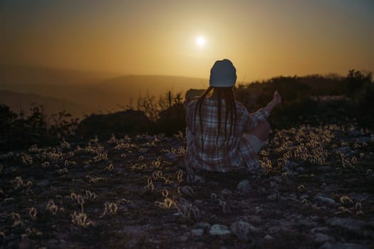 Woman tourist on top of sunrise mountain. The girl salutes the sun, wearing a jacket, white hat and white jeans. Conceptual design