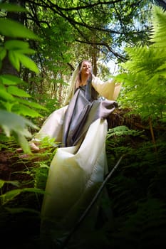 Beautiful seductive dryad. Pagan spirit of forest. Portrait of beautiful dryad. Fairy who loves nature in beautiful green summer forest. Concept of environmental friendliness and caring for nature