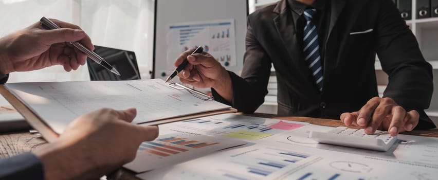 Two business people talk project strategy at office meeting room. Businessman discuss project planning with colleague at modern workplace while having conversation