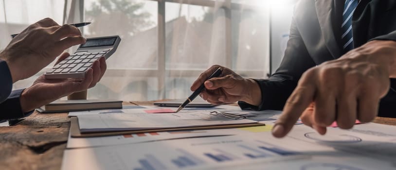 Two business people talk project strategy at office meeting room. Businessman discuss project planning with colleague at modern workplace while having conversation