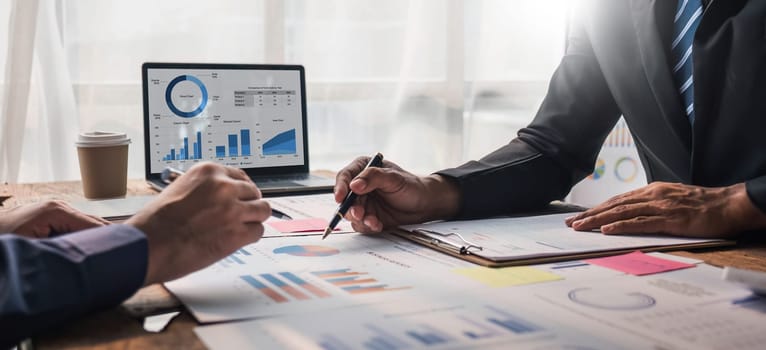 Two business people talk project strategy at office meeting room. Businessman discuss project planning with colleague at modern workplace while having conversation