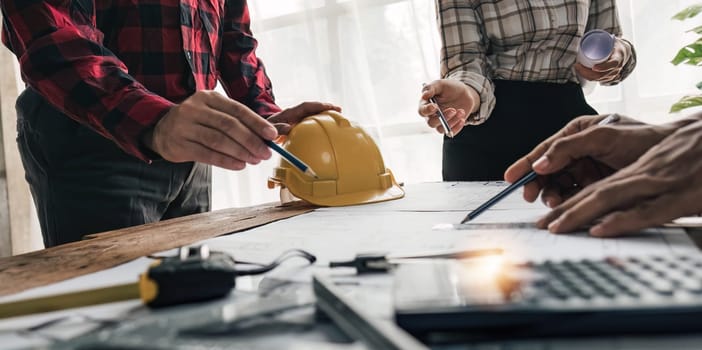 Civil engineer teams meeting working together wear worker helmets hardhat on construction site in modern city. Foreman industry project manager engineer teamwork. Asian industry professional team