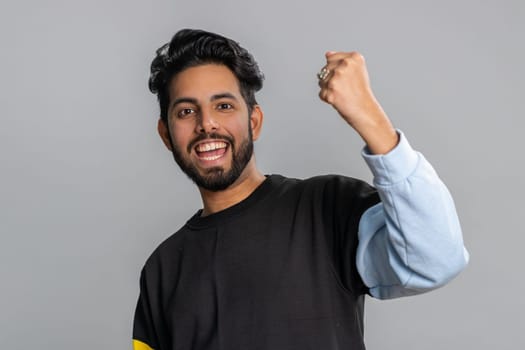 Happy joyful indian man shouting, celebrating success, winning, birthday, lottery jackpot goal achievemen, good news, victory, satisfaction. Young hindu guy isolated on gray studio background