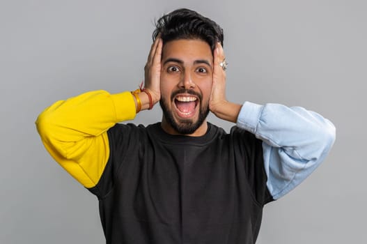 Dont want to hear and listen. Frustrated annoyed irritated indian man covering ears gesturing No, avoiding advice ignoring unpleasant noise loud voices. Handsome hindu guy alone on gray background