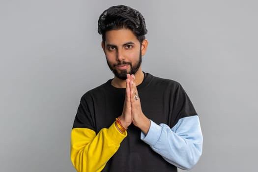 Sneaky cunning indian bearded man with tricky face gesticulating and scheming evil plan, thinking over devious villain idea, cunning cheats, jokes, pranks. Hindu guy isolated on studio gray background