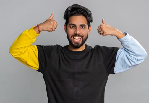 Happy joyful indian man shouting, celebrating success, winning, birthday, lottery jackpot goal achievemen, good news, victory, satisfaction. Young hindu guy isolated on gray studio background