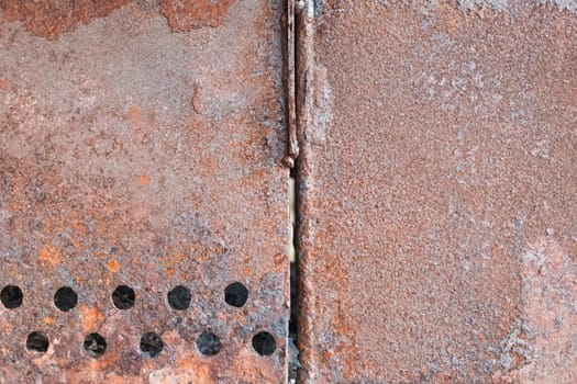 Old rusty grill with round holes pattern brown metal texture steel background.