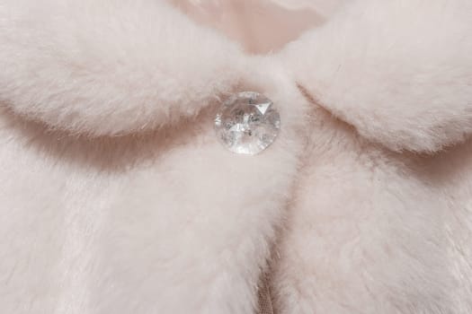 Women's white button clasp on cape made of artificial fur wool wedding element fragment object clothes close up of the bride.