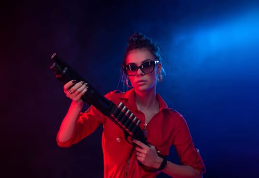 sexy hooligan girl in overalls with a shotgun on a dark background in neon light and haze copy paste
