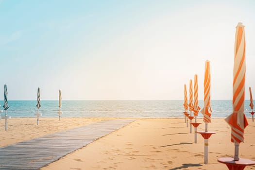 Closed umbrellas on the beach in Italy. The beach season is ready for opening. Travel concept