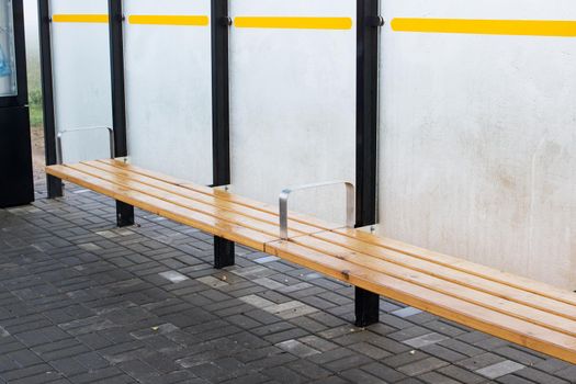 Wooden bench at the bus stop close up