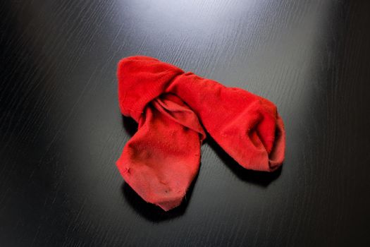 Dirty red socks on a wooden table close up