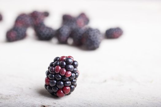 Close up of delicious blackberry on white wooden table