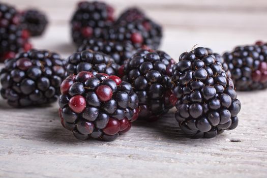 Close up of delicious blackberry on white wooden table