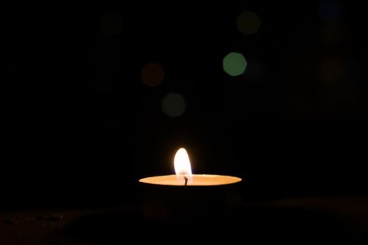 Burning candle on the background of night lights