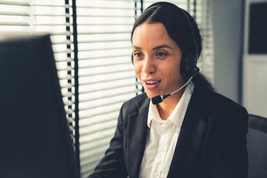 Competent female operator working on computer and talking with clients. Concept relevant to both call centers and customer service offices.