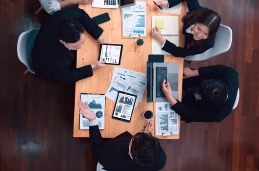 Top-view business team of financial data analysis meeting with business intelligence, report paper and dashboard on laptop for marketing strategy. Business people working together in office of harmony