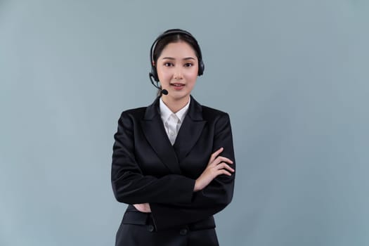 Attractive asian female call center operator with happy smile face advertises job opportunity on empty space, wearing a formal suit and headset on customizable isolated background. Enthusiastic