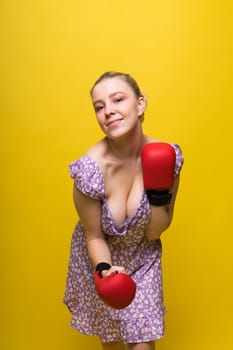 Seductive young and fit female fighter posing in gloves in a studio