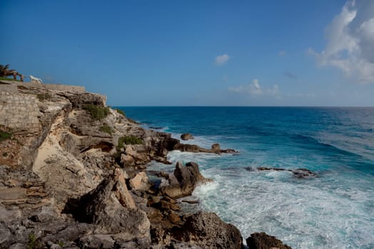 The coastline of the Caribbean Sea with white sand and rocks in Cancun.