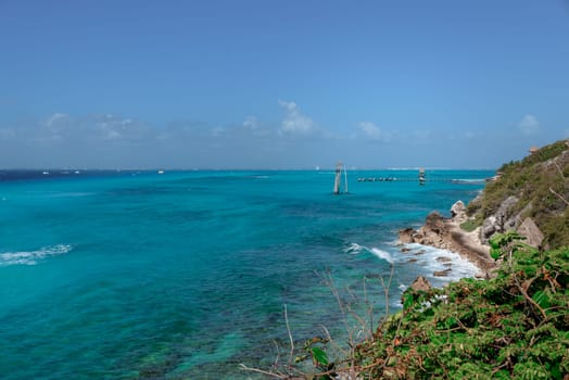 The coastline of the Caribbean Sea with white sand and rocks in Cancun.