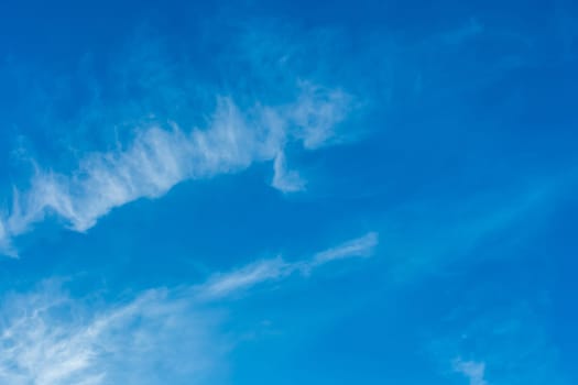 White cirrus clouds weather change wind natural background against the blue sky.