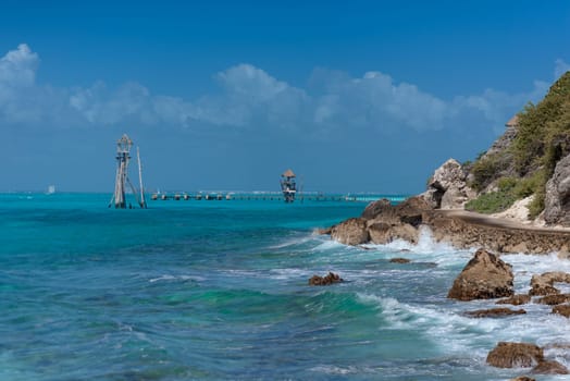 The coastline of the Caribbean Sea with white sand and rocks in Cancun.