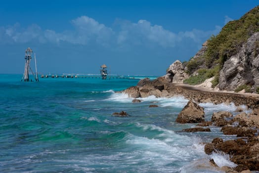 The coastline of the Caribbean Sea with white sand and rocks in Cancun.