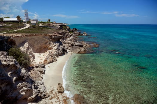 The coastline of the Caribbean Sea with white sand and rocks in Cancun.