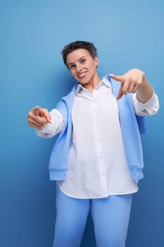 confident cool young lady with short haircut in white shirt on studio background.