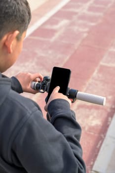 young man riding an electric scooter outdoors, looking at route on smartphone map application, sustainable transport concept, zero CO2 emission green energy