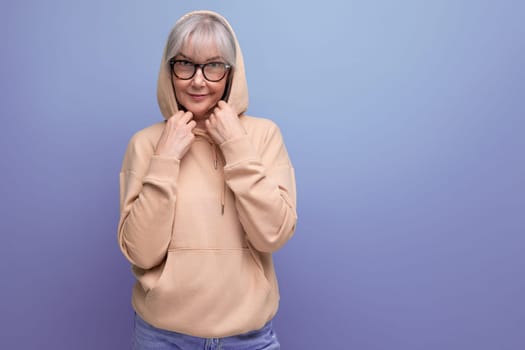 middle-aged woman in gray hair in a stylish jacket on a studio background with copy space.